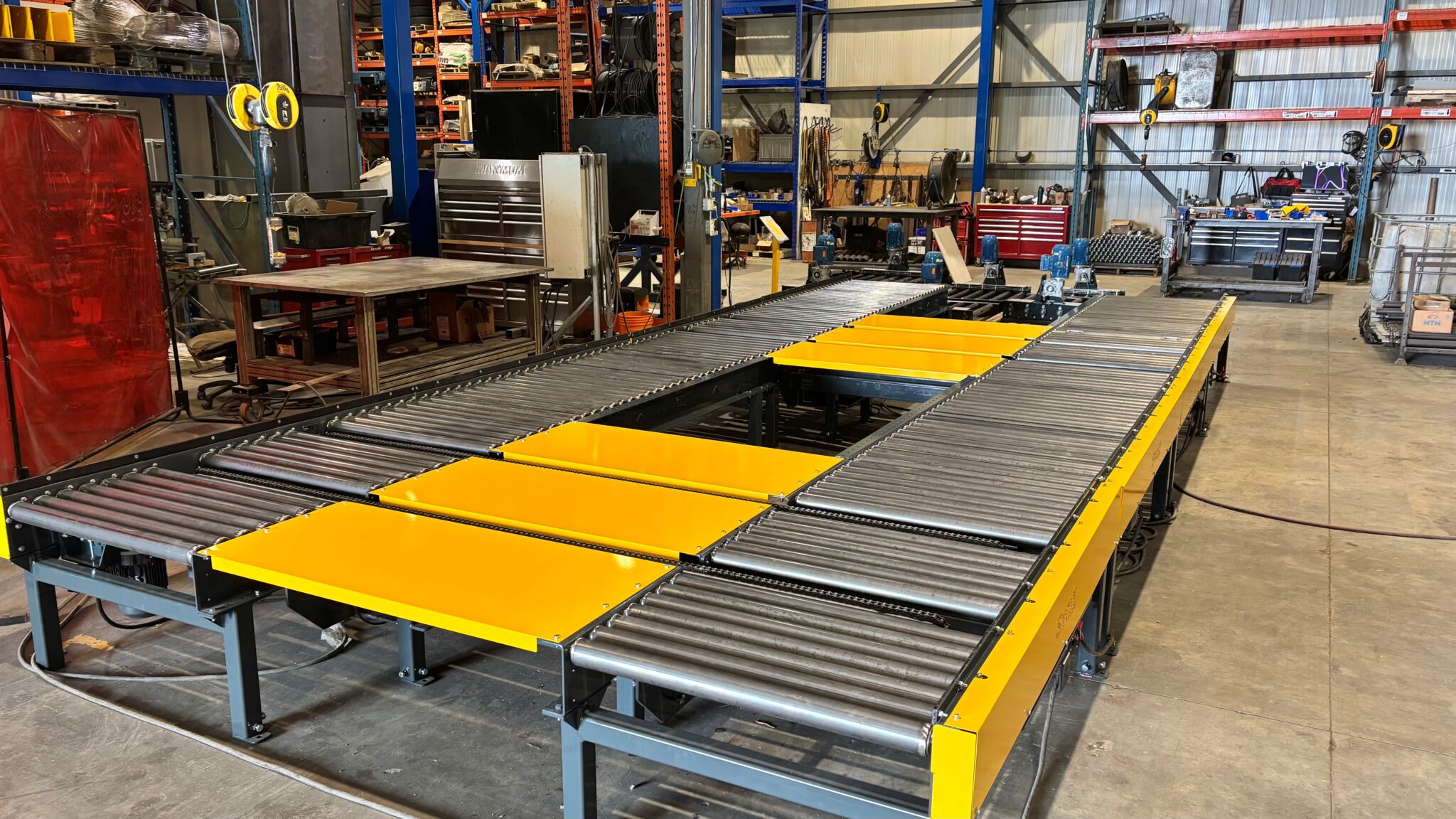 Transfert à chaînes dans convoyeurs à rouleaux